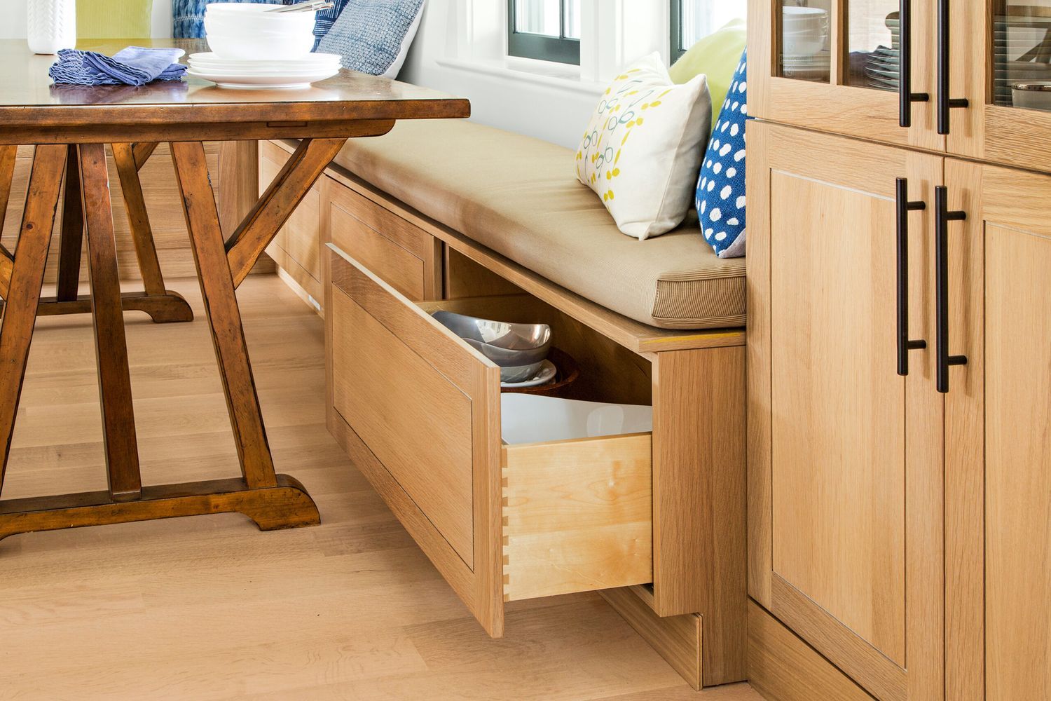 a large storage drawer underneath a seat in a kitchen