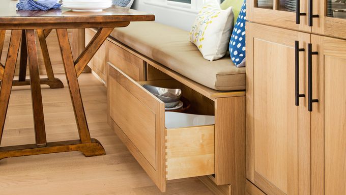 a large storage drawer underneath a seat in a kitchen