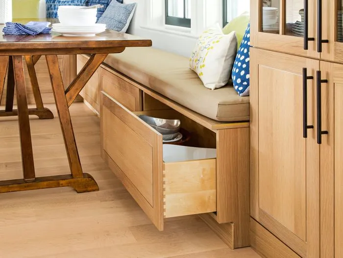 a large storage drawer underneath a seat in a kitchen