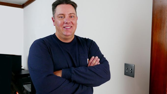 A man standing next to an antique light switch