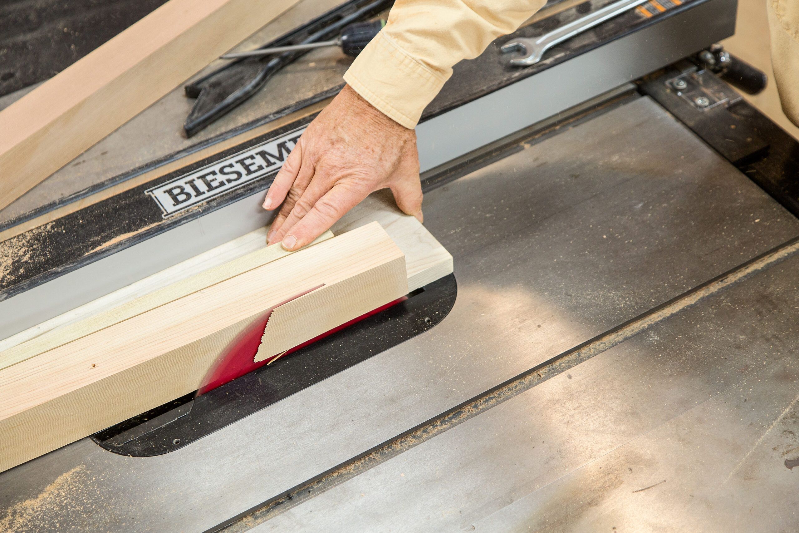 A saw blade is used to cut cedar pieces to the right width for the planter box.