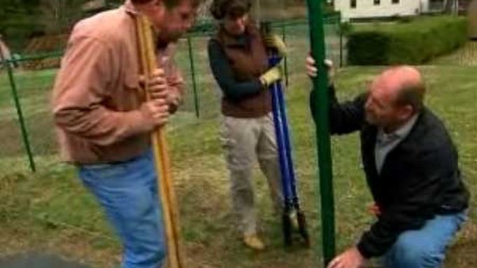 3 Men using a posthole digger to install a post.