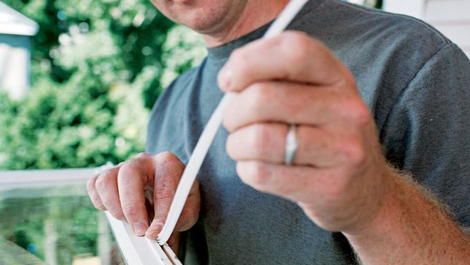 Image of Kevin O' Connor demonstrating how to add weatherstripping to a double-hung window.