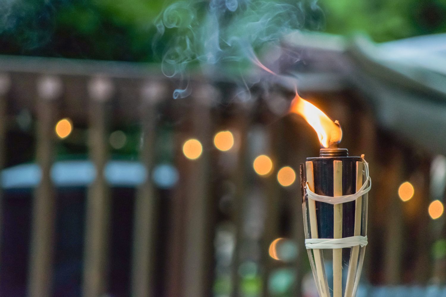 a tiki torch in a backyard that is lit