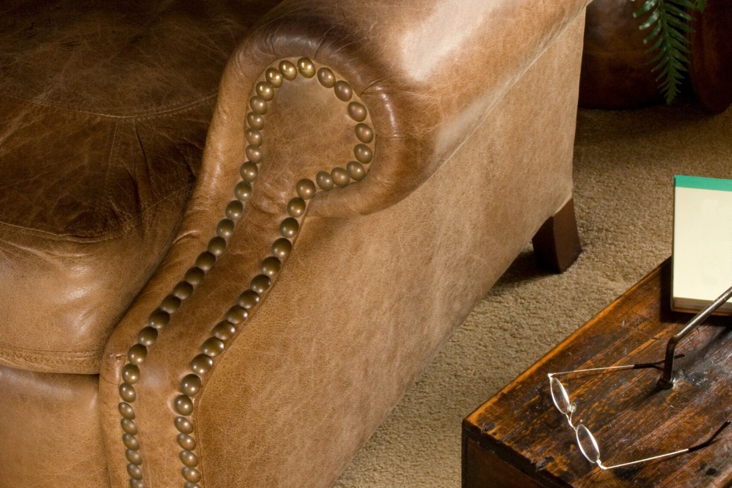 Worn brown leather chair in need of repair.