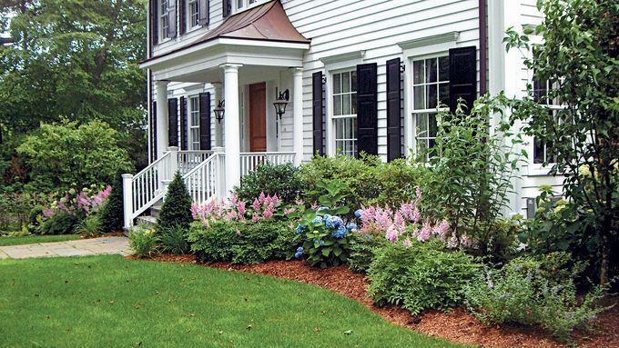 A home with various plants included in it foundation planting.