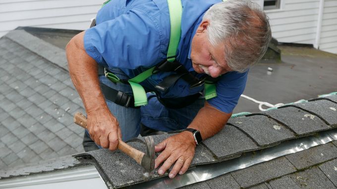 Installing a zinc strip to keep roof algae from coming back.