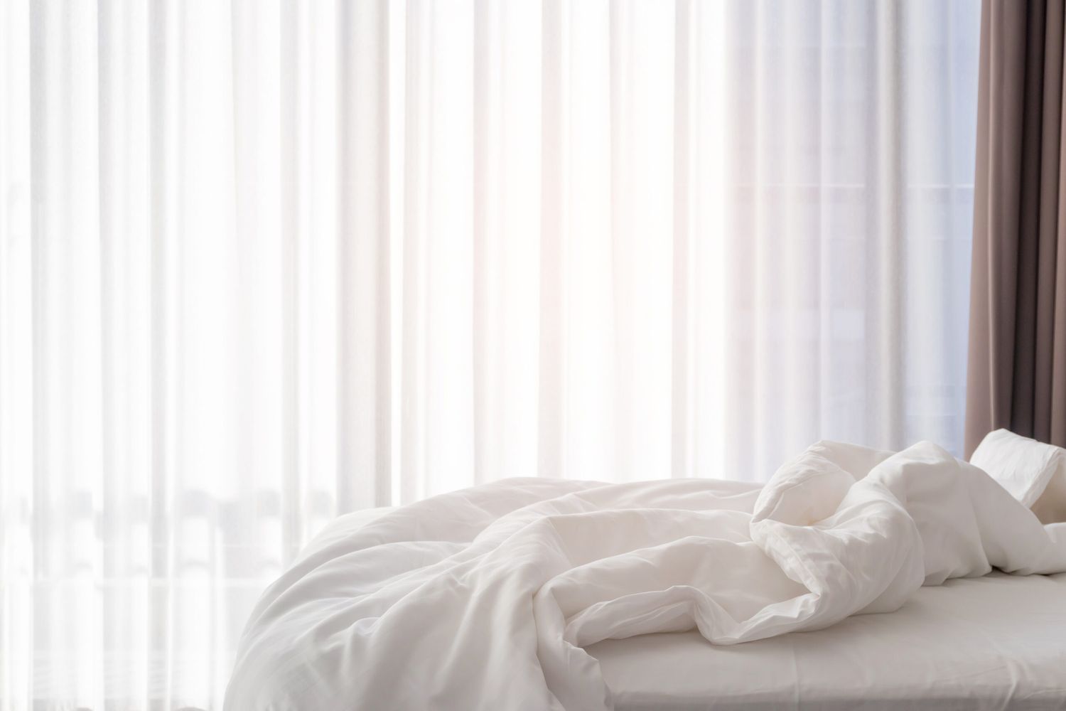 A bedroom with gentle light coming through to aid with sleep.