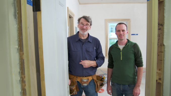 Two men standing next to a repurposed door.