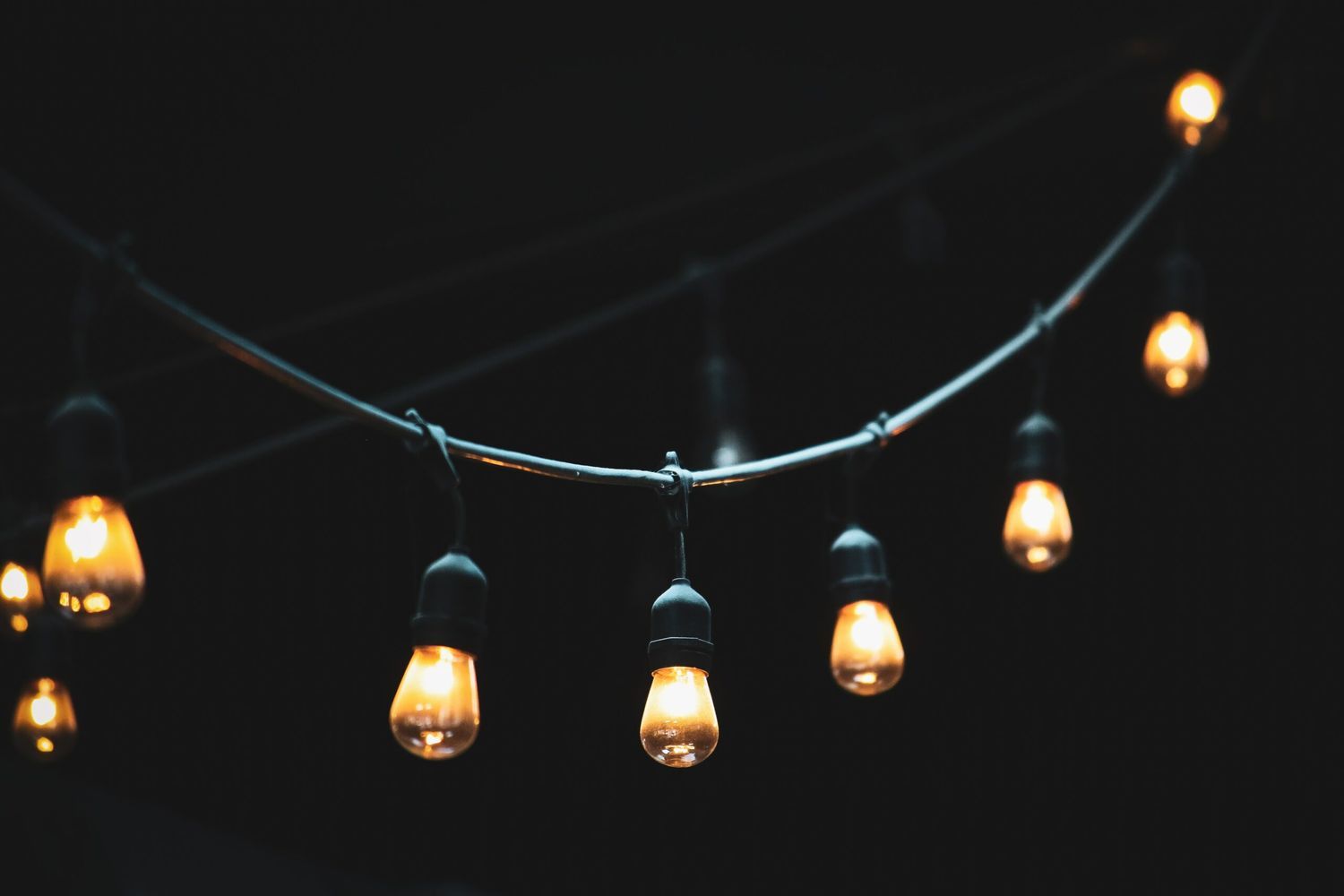 A string light setup shining in the dark.