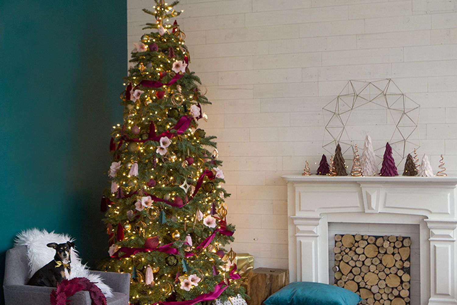 A Christmas tree in front of a fireplace.