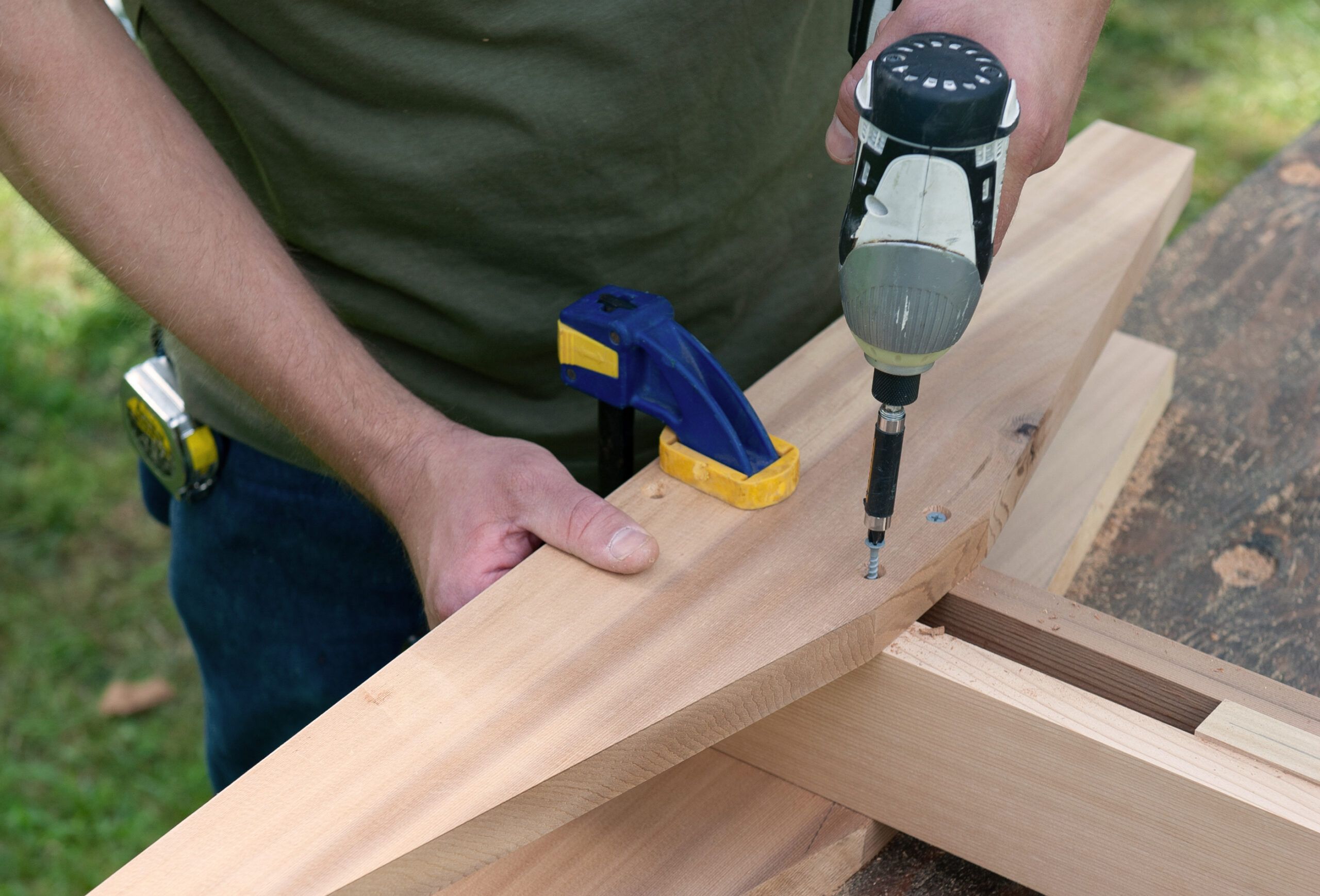 Image of the twelfth step of building a DIY picnic table and benches, which is to attach the feet and brackets