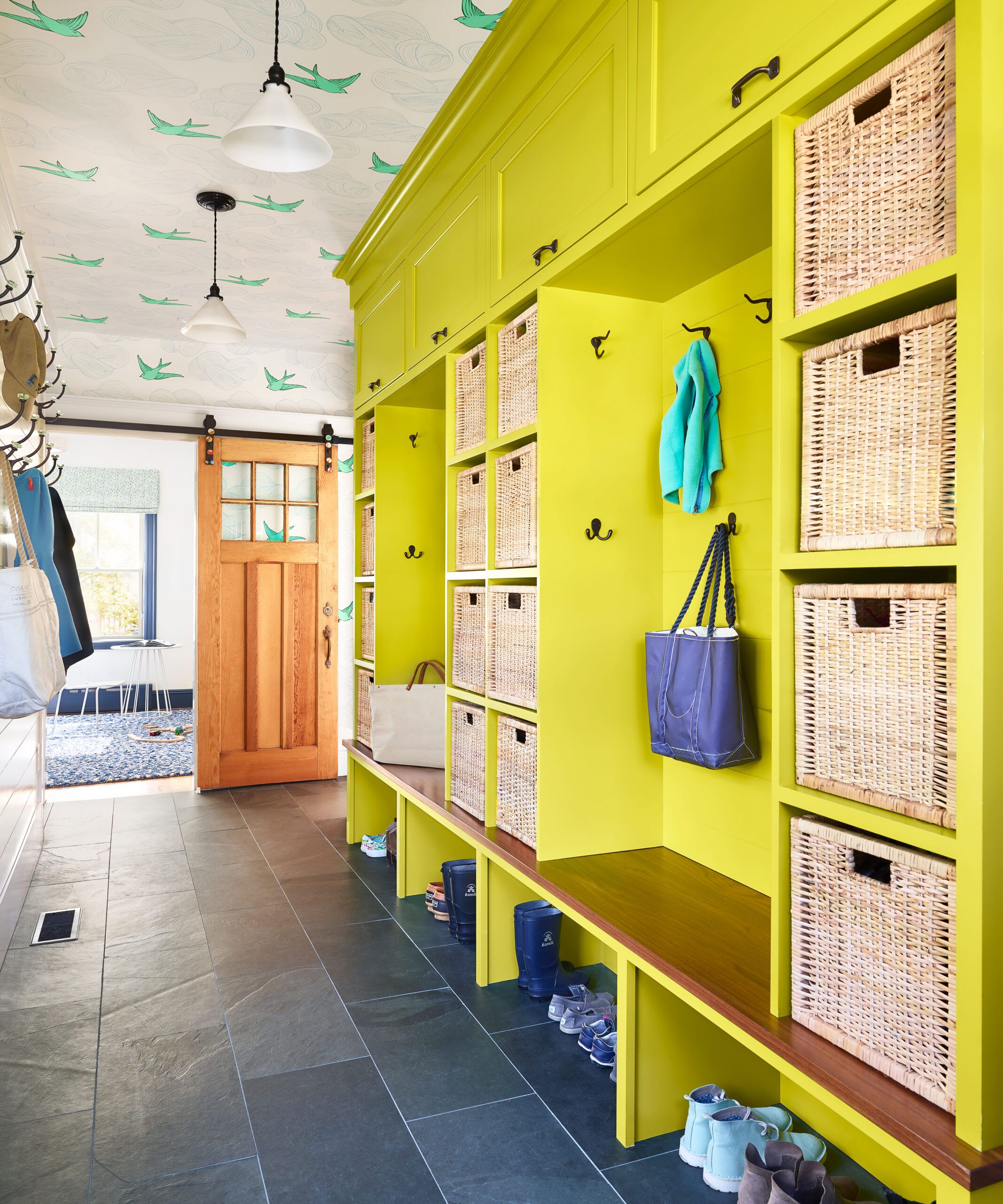 A mudroom with brightly painted built-in cubbies.