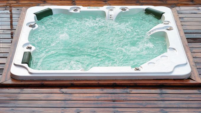 A clean hot tub installed on a wooden deck.