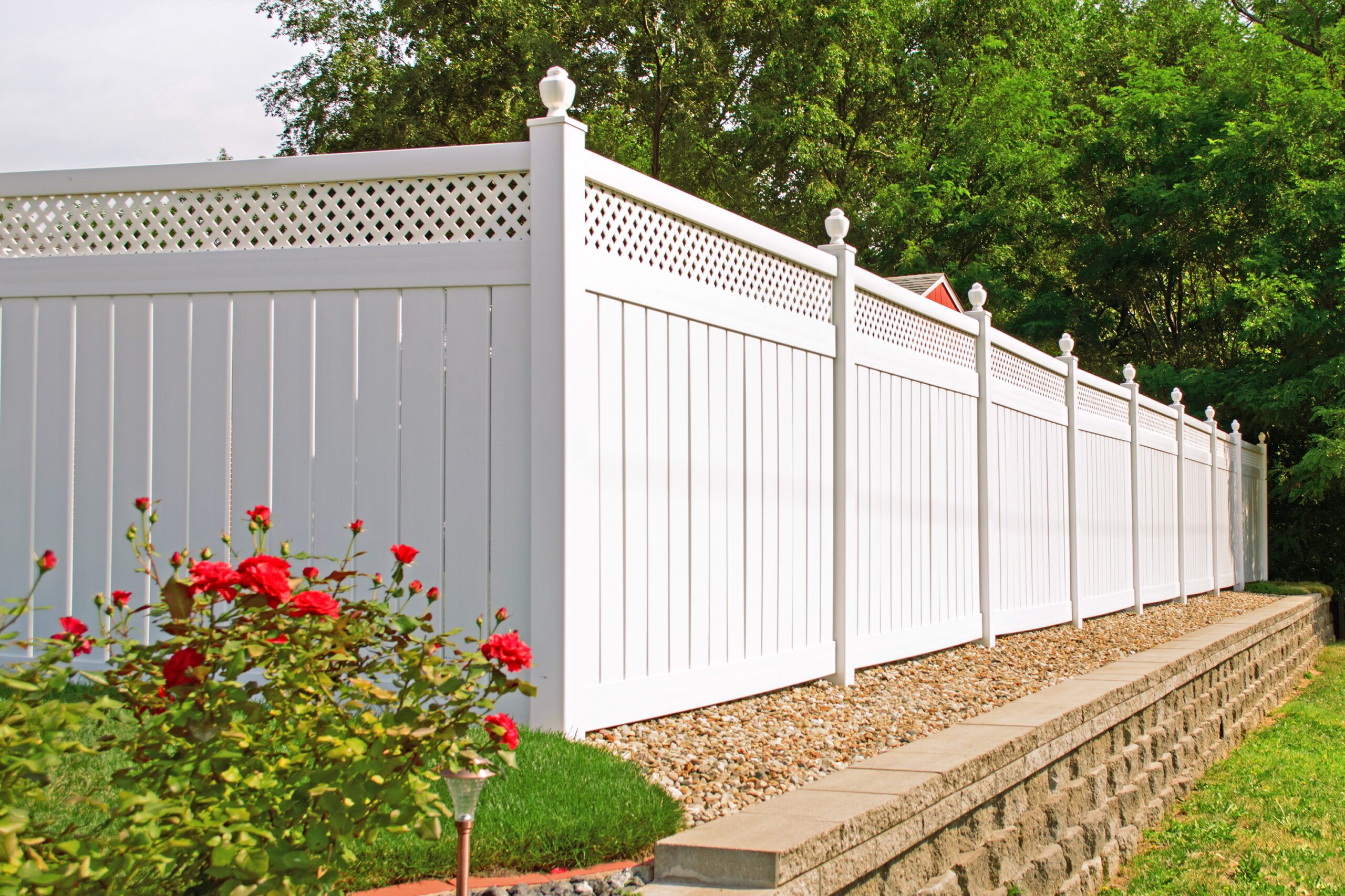 A white vinyl fence in a yard.