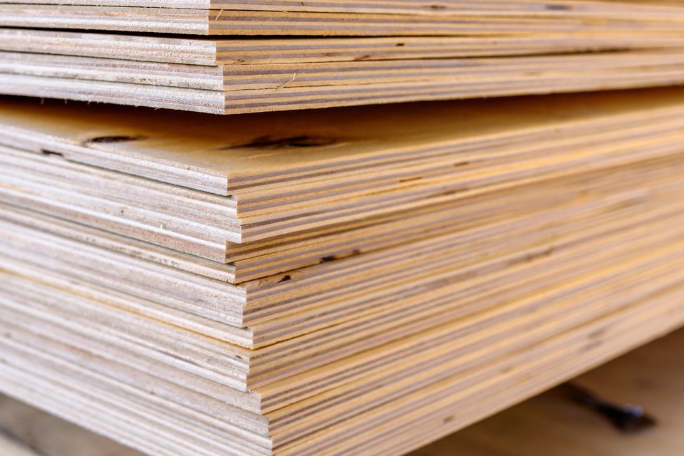 A tall stack of plywood boards.