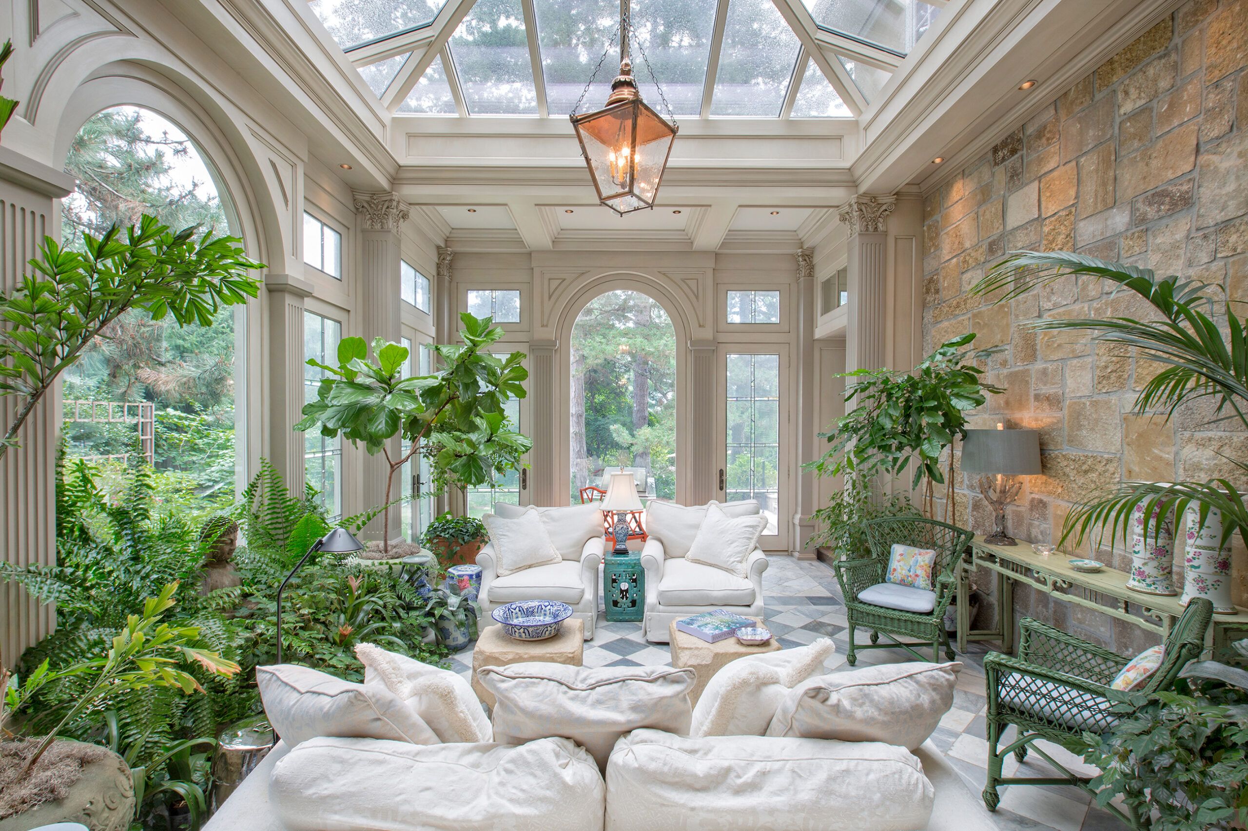 Image of a traditional green-house inspired sunroom with many plants and seating options