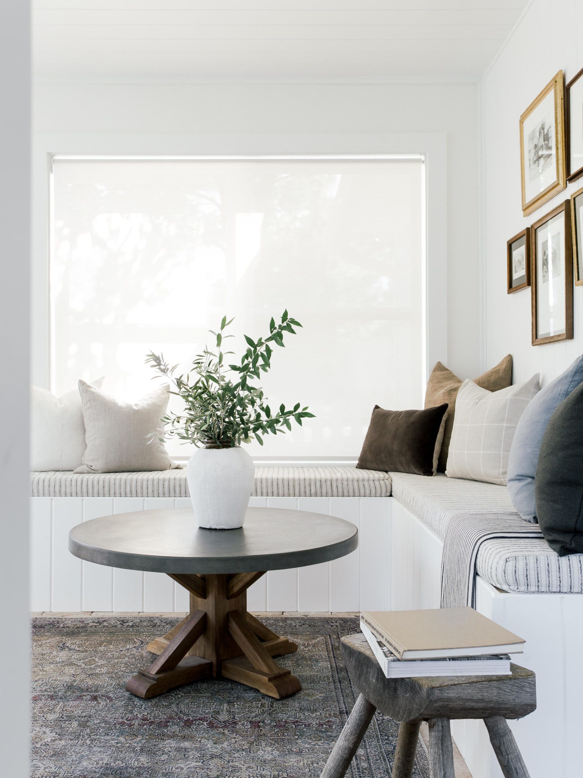 Image of a small sunroom with a built-in bench around the wall and a table in the center with a plant on it