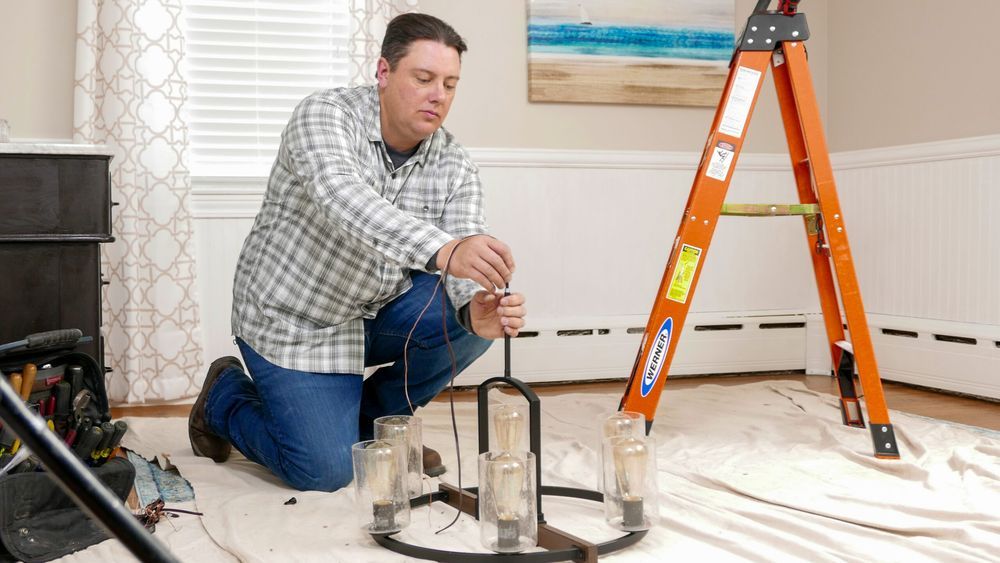 Electrician installing a ceiling light.