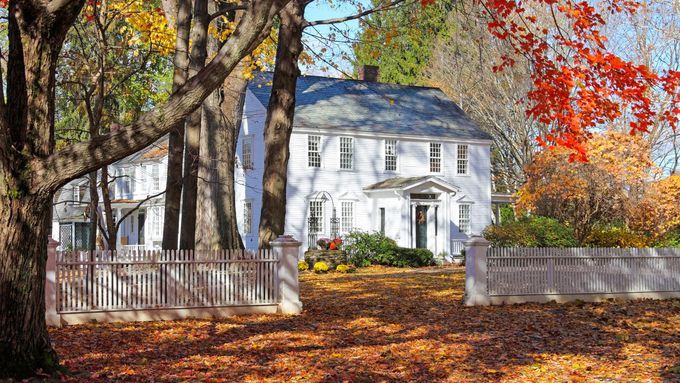 A house with a yard covered in Fall leaves.