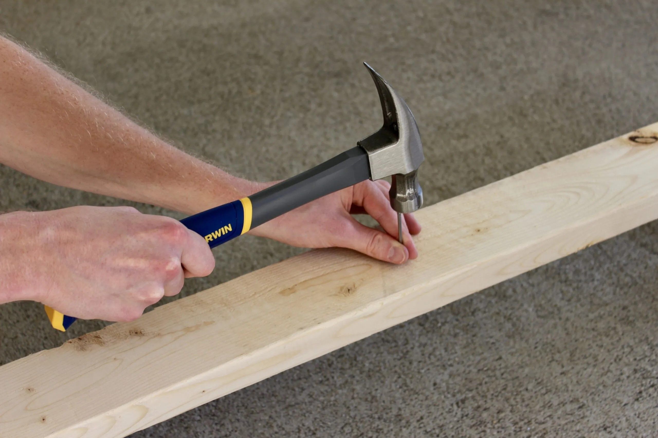 driving a nail into a 2x4 board with an Irwin 16-Ounce Fiberglass Hammer