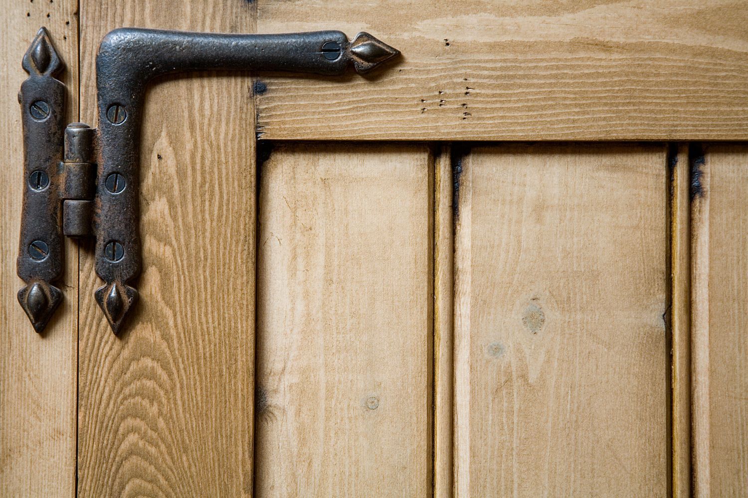A hinge on the corner of a cabinet door.