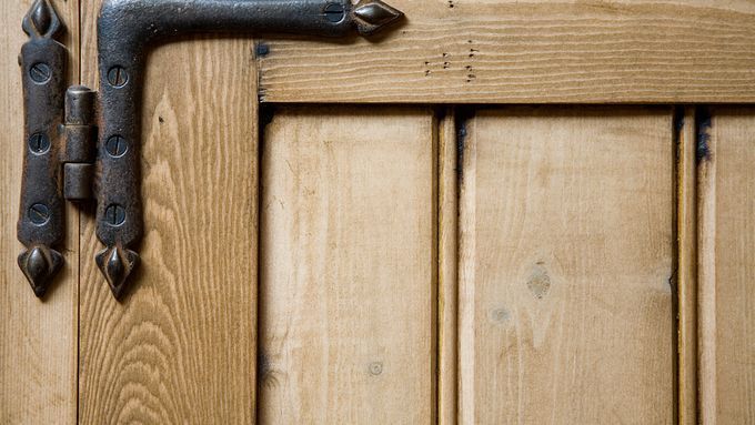 A hinge on the corner of a cabinet door.