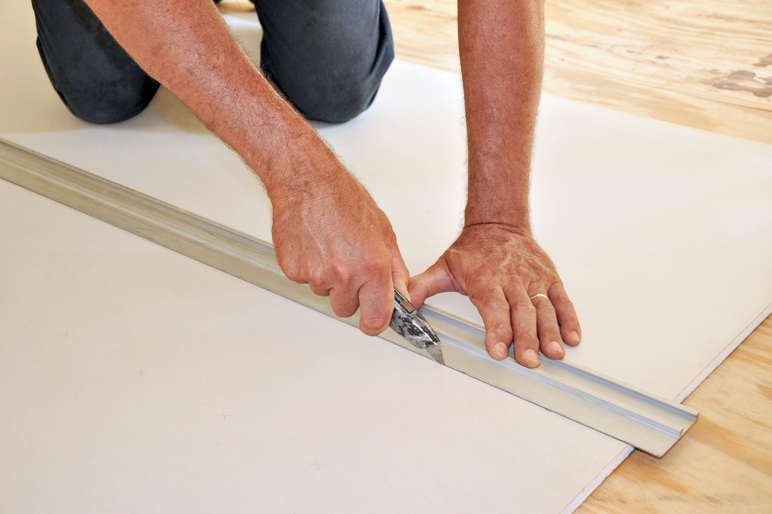 A person cutting drywall.