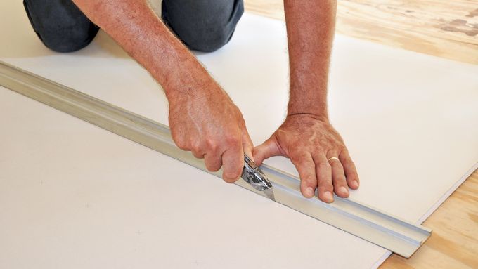 A person cutting drywall.