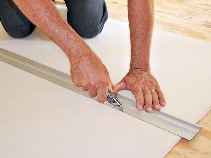 A person cutting drywall.