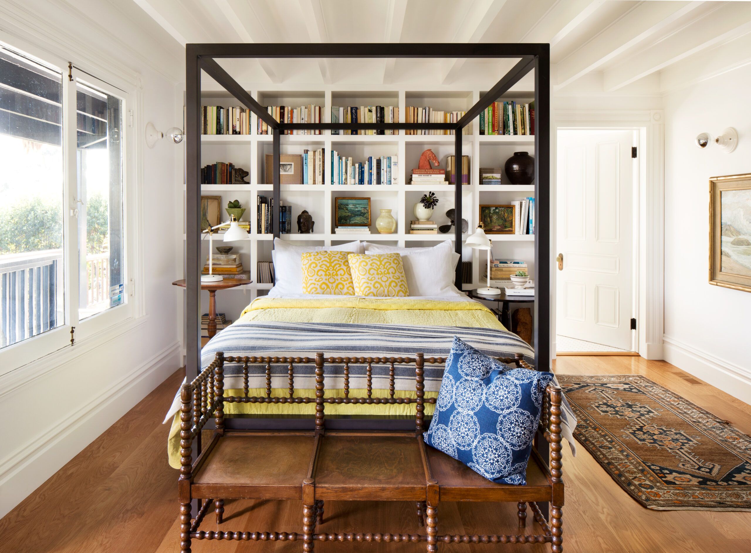 Built-in bookshelves behind a bed.