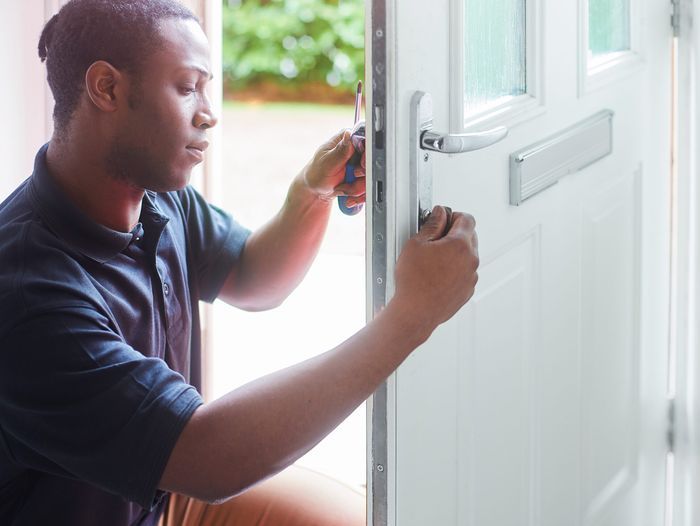 Person rekeying a lock on the door of a residential home