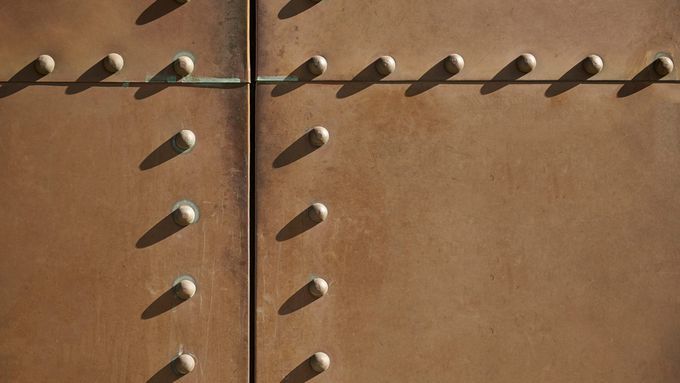 A set of rivets in a wall to be removed.