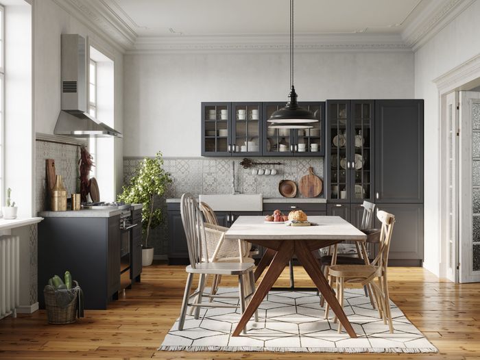 A kitchen with hardwood flooring and large windows.