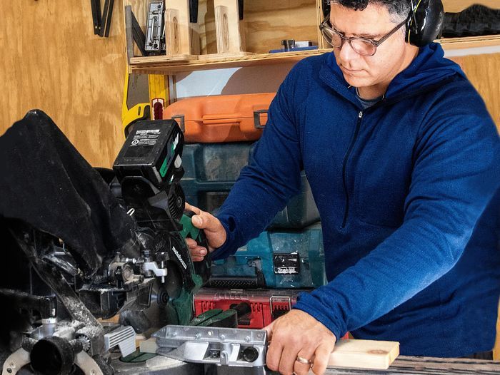 A man using a miter saw on a table