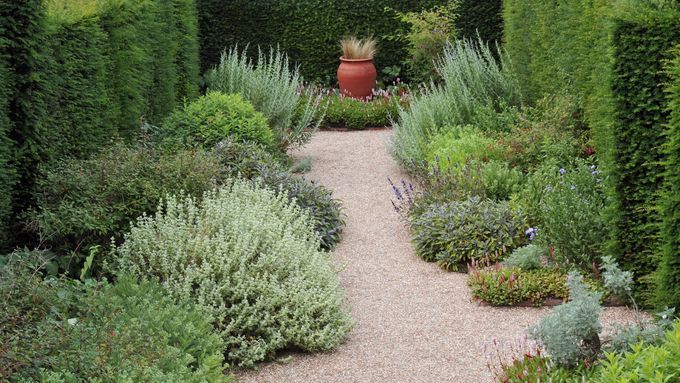 a gravel walkway and surrounding bushes