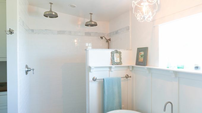 A bathroom with a bathtub on the right side and a shower against the back wall.