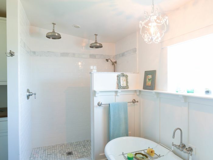 A bathroom with a bathtub on the right side and a shower against the back wall.
