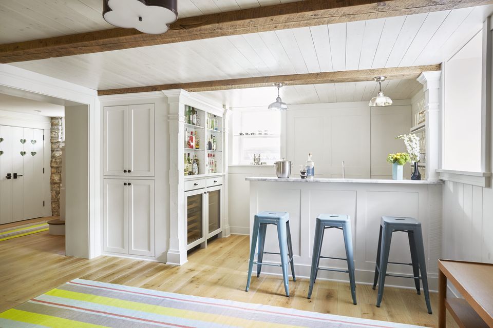 A basement kitchen with a breakfast bar and a painted wood plank ceiling.