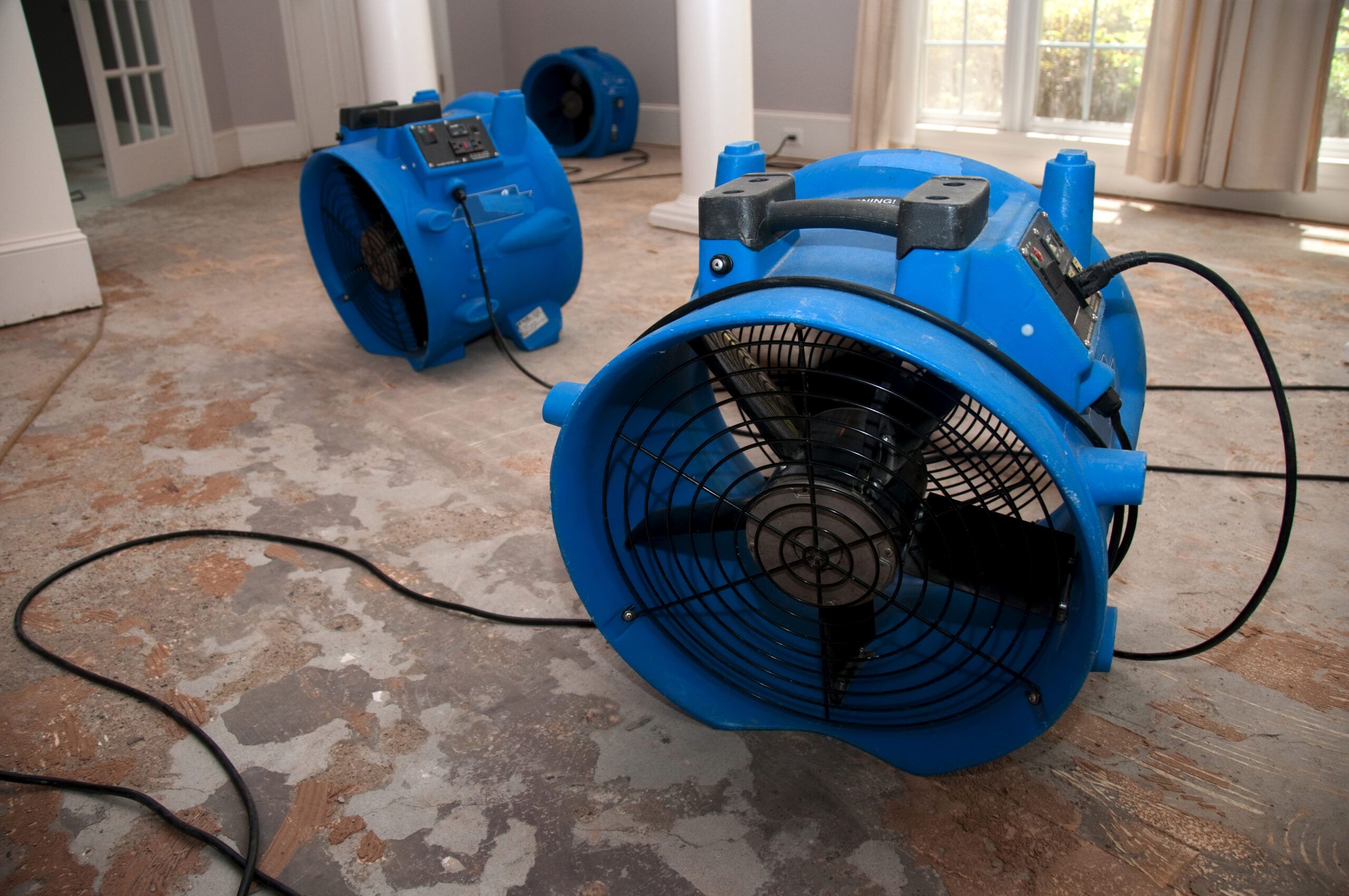 Image of fans inside a house to help dry water damage sustained from fire damage.