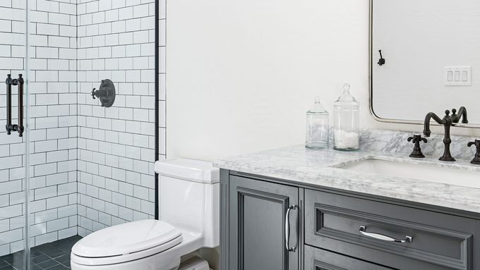 A Toilet sitting in a bathroom beside a sink and shower.