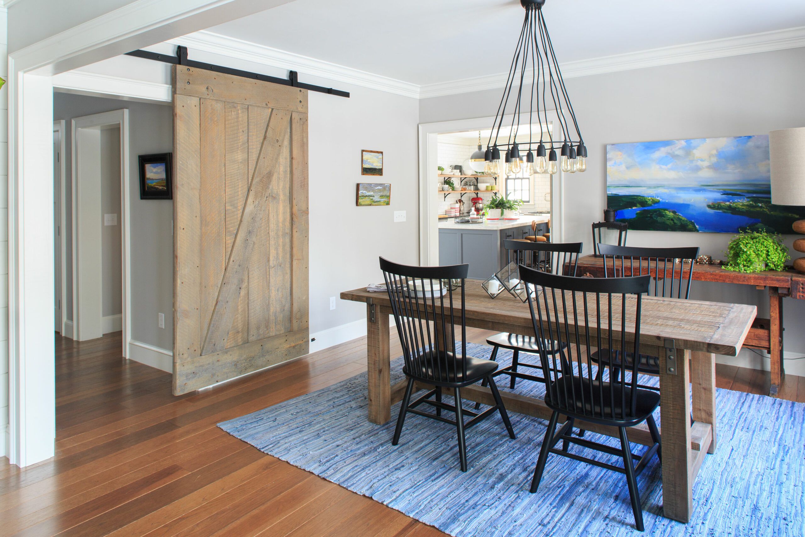 A sliding shiplap door in a dining room.