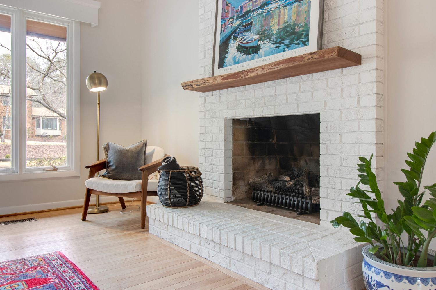 A painted brick fireplace in a modern living room.