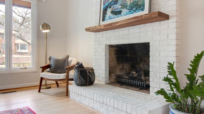 A painted brick fireplace in a modern living room.