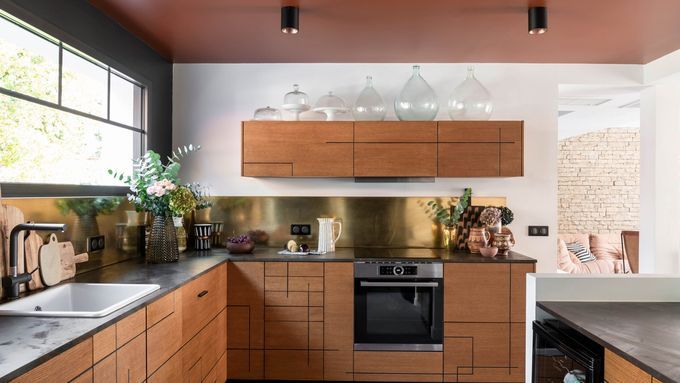 A modern kitchen with a clay colored ceiling.