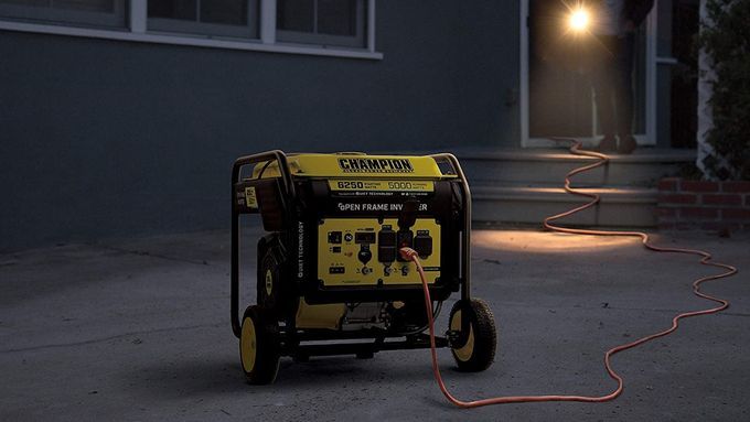 Image of a yellow and black backup power generator outside of a home at night. Lead image for This Old House's Best Home Generators guide