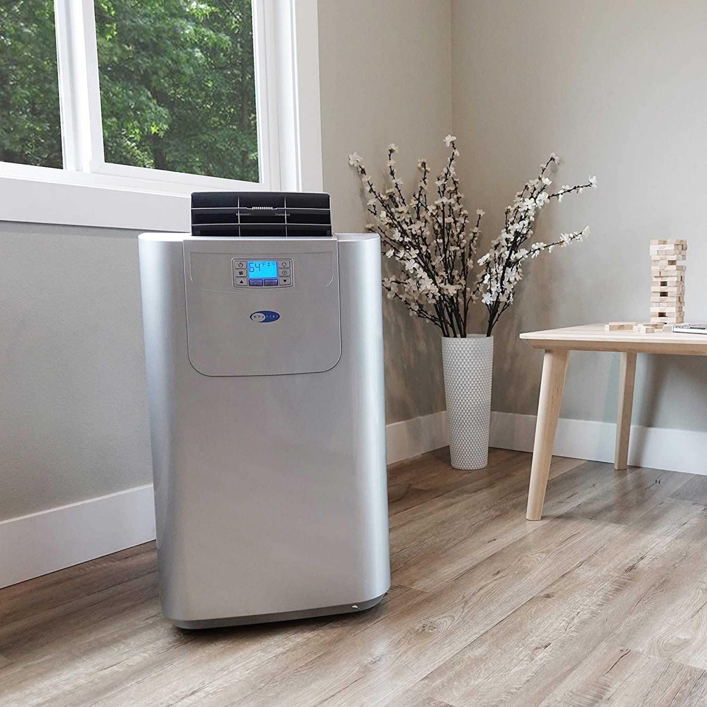 Featured image for This Old House's best portable air conditioner guide, one of the best portable air conditioners in silver, located inside a home.