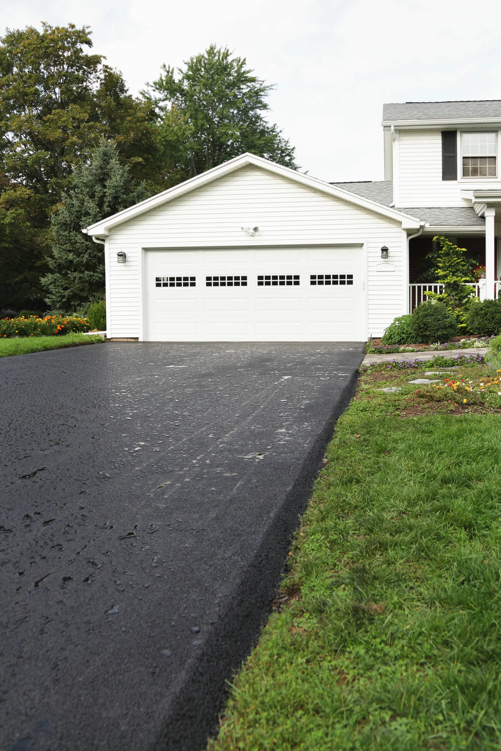White with a newly replaced wet asphalt driveway.