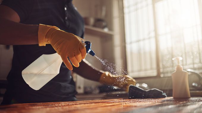 A person cleans a butcher block.