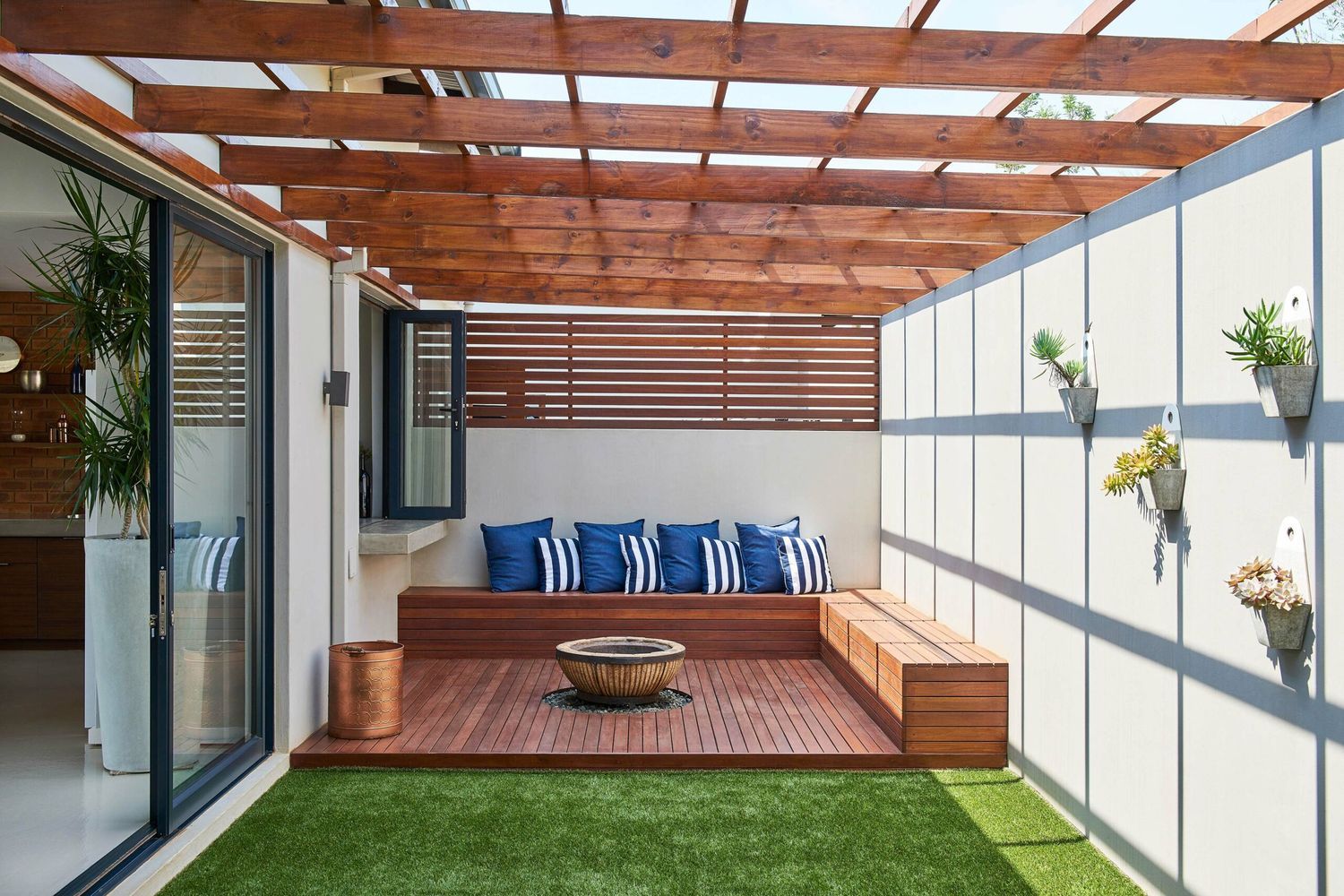 A pergola with benches and a fire pit in its center